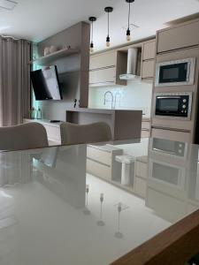 una cucina con elettrodomestici bianchi di Encanto dos Mares - Apartamento premium 4 a Camboriú