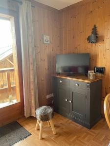 a room with a cabinet with a television and a stool at Appartement 6 places La Toussuire in La Toussuire