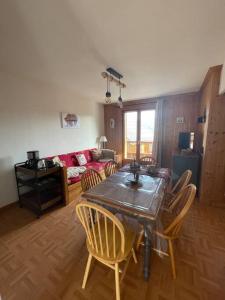 a living room with a table and chairs and a couch at Appartement 6 places La Toussuire in La Toussuire