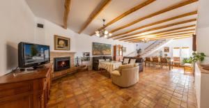 sala de estar con TV y chimenea en Vivienda Rural Las Bartolas en Jaén