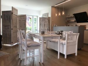 eine Küche mit weißem Tisch, Stühlen und Schränken in der Unterkunft Ferienwohnung Seaflat in Strandnähe, Strandkorb, Kamin, free W-LAN by SEASIDE in Rosenhagen