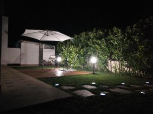 a patio at night with an umbrella and lights at Le Stelle di Orione in Fontane Bianche