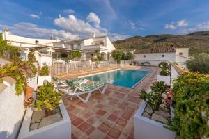 eine Villa mit einem Pool und einem Haus in der Unterkunft Vivienda Rural Las Bartolas in Jaén