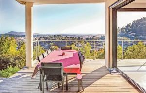 ein Esszimmer mit einem rosa Tisch und Stühlen auf einer Terrasse in der Unterkunft Beautiful Home In La Valette Du Var With Wifi, Private Swimming Pool And Outdoor Swimming Pool in La Valette-du-Var