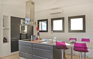 ラ・ヴァレット・デュ・ヴァールにあるAwesome Home In La Valette Du Var With Kitchenのキッチン(紫色のバースツールとカウンター付)