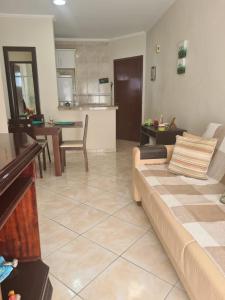 Il comprend un salon avec un canapé et une cuisine. dans l'établissement Apto a 50m da praia, com ar condicionado, wifi , portaria 24h, à Praia Grande