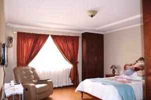 a bedroom with a bed and a chair and a window at Cozy and Spacious Home with Incredible Location in Cuenca