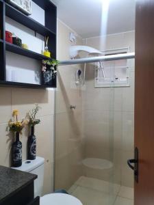 uma casa de banho com uma cabina de duche em vidro e um WC. em Bedroom Airport em Maceió