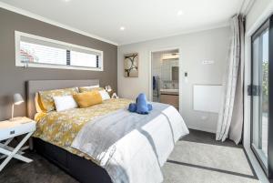 un dormitorio con una cama con un animal de peluche azul en Citron 9 en Greytown