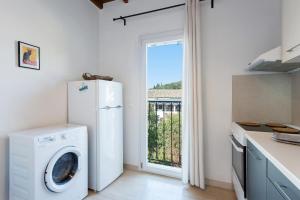 a kitchen with a white refrigerator and a washing machine at Tati Apartment in Kassiopi