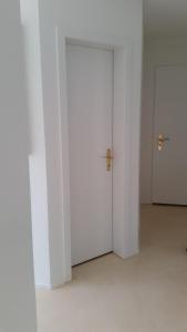 an empty room with white walls and two doors at 2,5 Zimmer Apartment in Zürich
