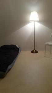 a lamp in a room with a bed and a chair at 2,5 Zimmer Apartment in Zürich