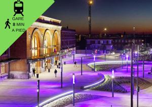 a group of people walking around a city at night at Grand T2 Jardin Wifi Parking Proche Gare in Saint-Quentin