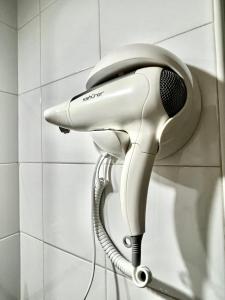 ein Telefon, das an einer Wand im Bad hängt in der Unterkunft Guest House Leo in Alicante