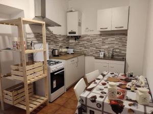una cucina con un tavolo e una stufa forno superiore di Locazione turistica di Via Ottaviano a Roma a Roma Altre 32 foto