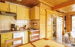 a kitchen with yellow cabinets and a table and chairs at Stunning Home In Stawiguda With 3 Bedrooms And Wifi in Stawiguda