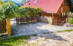 a fence in front of a house with a yard at Beautiful Home In Stawiguda in Stawiguda