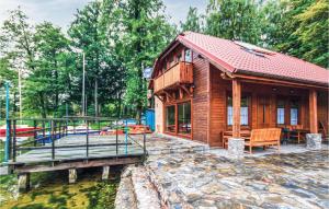 a log cabin by the water with a dock at Stunning Home In Stawiguda With House Sea View in Stawiguda