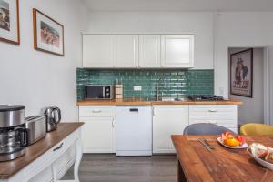 a kitchen with white cabinets and a wooden table at Paul Robeson Str. II in Berlin