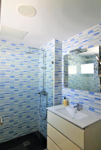 a bathroom with a sink and a shower with blue tiles at Apartamento Martina in Puerto del Carmen +10 photos
