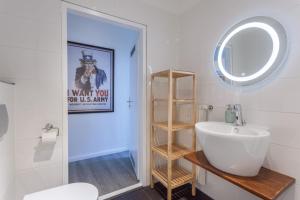 ein Badezimmer mit einem weißen Waschbecken und einem Spiegel in der Unterkunft Paul Robeson Str. II in Berlin