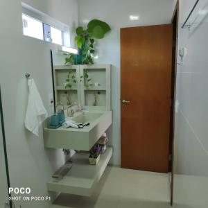 uma casa de banho com um lavatório e um espelho em APTO Maison Class - 3 quartos próximo ao shopping em Foz do Iguaçu