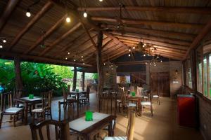 a restaurant with wooden tables and chairs and lights at La Aldea De La Selva Lodge in Puerto Iguazú