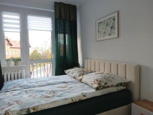 Postel nebo postele na pokoji v ubytování Szmaragdowy apartament