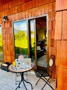 uma mesa com um computador portátil no pátio em Rio Blanco em Hornopiren