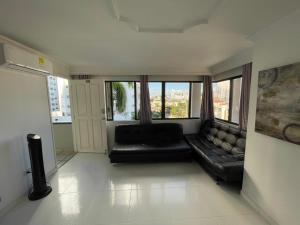 a living room with a black couch and large windows at Vista Al Mar, Aire Acondicionado en Todo el Apto, Wi-Fi, Parqueadero in Cartagena de Indias