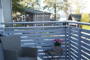 a deck with white rails and a table with flowers on it at Landhotel Strandallee in Wunstorf