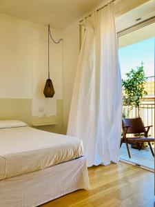 a bedroom with a bed and a window with a chair at UN PUNTO A VERONA in Verona