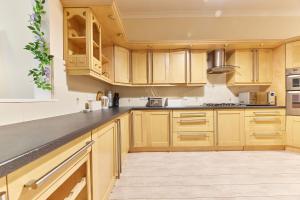 a kitchen with wooden cabinets and stainless steel appliances at A *Spacious* 3 Bedroom Flat - Town Centre Berwick Upon Tweed in Berwick-Upon-Tweed