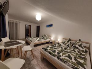sypialnia z 2 łóżkami, stołem i krzesłami w obiekcie FeWo2&Bad Wurzach w mieście Bad Wurzach