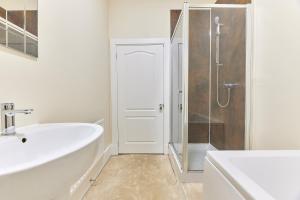 a white bathroom with a sink and a shower at A *Spacious* 3 Bedroom Flat - Town Centre Berwick Upon Tweed in Berwick-Upon-Tweed