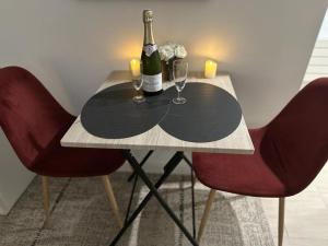un tavolo con due bottiglie di vino e due bicchieri di Les pieds dans l'eau ALOHA a Corné
