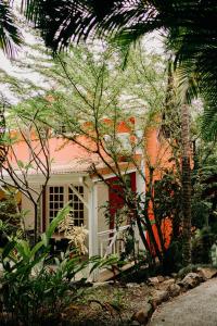une maison blanche et orange avec des arbres devant elle dans l'établissement Caraib'Bay Hotel, à Deshaies