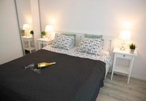 - une chambre avec un grand lit et une bouteille dans l'établissement Luxus Apartament Fitness&Spa z sauną i siłownią, à Gdańsk