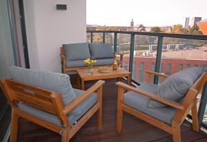 - un balcon avec vue doté de 2 chaises et d'une table dans l'établissement Luxus Apartament Fitness&Spa z sauną i siłownią, à Gdańsk