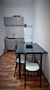 a kitchen with a black table and two chairs at Complejo San Antonio in Fiambala