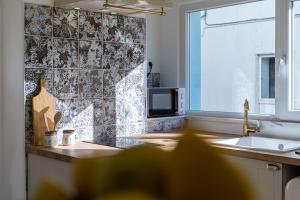 uma cozinha com um lavatório e um micro-ondas em Casa Estábulo- Cozy Rustic Farmhouse (HORSE LOFT) em Estômbar