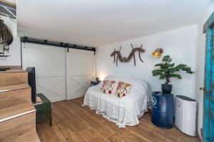 um quarto com uma cama branca e uma árvore em Casa Estábulo- Cozy Rustic Farmhouse (HORSE LOFT) em Estômbar