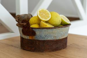 a bucket of lemons on a wooden table at Casa Estábulo- Cozy Rustic Farmhouse (HORSE LOFT) in Estômbar +13 photos