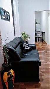 un divano in pelle nera, situato in un soggiorno. di Complejo San Antonio a Fiambalá