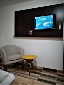 a living room with a chair and a table and a tv at Complejo San Antonio in Fiambalá