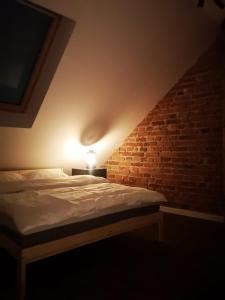 a bedroom with a bed and a brick wall at Browarna 14 jacuzzi, prestige in Racibórz