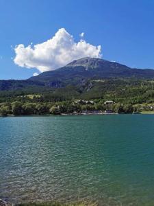 una montaña en la distancia con un gran cuerpo de agua en Duplex cocooning avec vue lac et montagnes en Savines