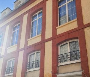 迪耶普的住宿－Au coin du Quai entre Mer et Port de plaisance，红砖建筑,设有窗户和阳台