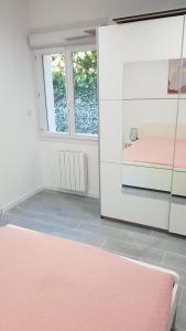 マルセイユにあるgite sous l'olivierのピンクベッド1台と鏡が備わる客室です。