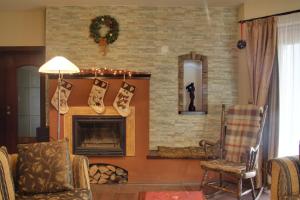 a living room with a fireplace with christmas ornaments at Villa Corvina in Győrújbarát +51 photos